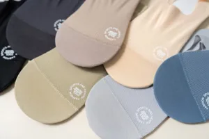 Dettagli di calzini invisibili estivi traspiranti da uomo in rete con fondo in spugna in vari colori.