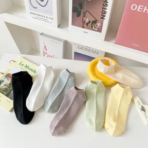 Gros plan de chaussettes basses unies respirantes en maille disposées proprement.