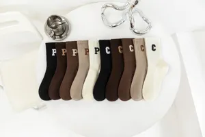 Detailed view of vintage solid color mid-tube socks with letter embroidery, soft cotton material.