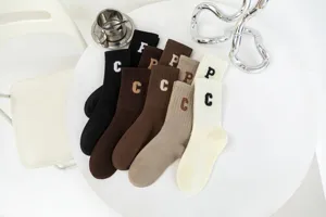 Cozy knit mid-tube socks with stylish letter embroidery, solid retro colors for women daily wear.