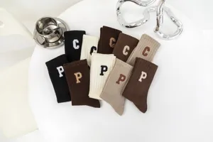 Solid color ribbed mid-tube socks featuring letter embroidery for daily autumn wear.