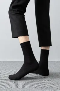 Detail view of men's black ribbed mid-calf socks showing texture and daily wear look clearly.