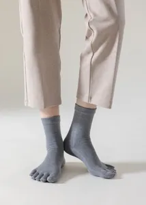Detail shot of grey five-toe socks, comfortable mid-tube knit design for yoga and fitness.