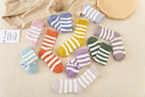 Close up of colorful striped fuzzy coral fleece cozy winter socks flat lay detail shot.