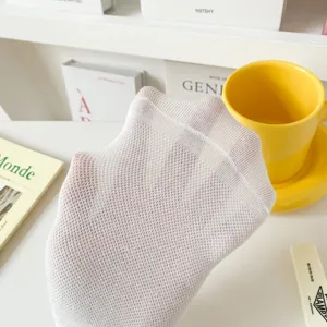 Détail de chaussettes courtes en maille blanche montrant la texture respirante.