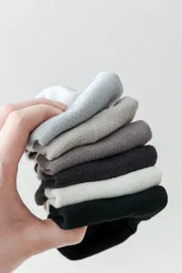 Close-up detail of stacked breathable cotton mesh boat socks in various neutral colors.