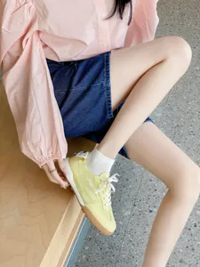 Primer plano detallado de elegantes zapatillas casuales amarillas combinadas con calcetines.