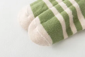 Green and white striped terry socks detail, soft cotton warm sock close-up view.
