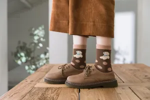 Detail shot of winter brown mid-calf socks featuring cute puppy and polka dot patterns.