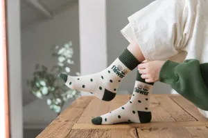 Close-up of women's thermal terry socks with cute green polka dot and flower print details.