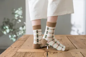Detail shot of cozy plaid loop socks featuring brown heel and ribbed cuff design.