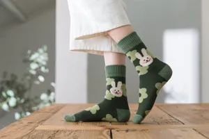 Detailed close-up view of cute green rabbit pattern short towel socks for warm winter wear