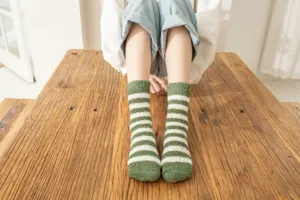 Green and white striped fuzzy plush socks detail shot, cozy winter warm thick socks view.