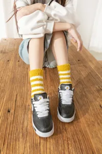 Thickened coral fleece cozy warm mid-tube socks featuring cute yellow and white stripes design.