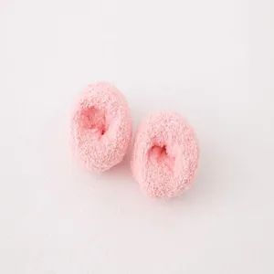 Pink fluffy plush pom poms for cute socks, soft coral fleece material, cosy winter style.