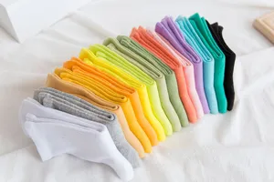 Primo piano dettagliato di calzini medi colorati in cotone da donna disposti in modo ordinato.