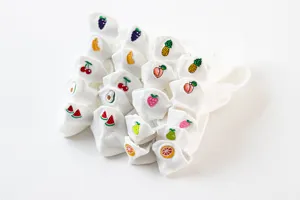 Detailed shot of white short socks featuring cute embroidered fruit patterns, sweet style.