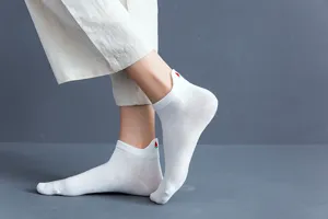 Close-up detail of women's white low-cut socks featuring cute watermelon heel decoration.