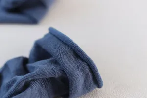 Close-up detail of women solid blue slouch socks soft knitted texture rolled cuff