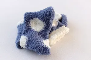 Close up detail of soft coral fleece fuzzy socks showing plush warm texture and pattern.