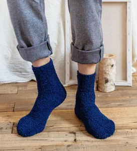 Close-up of cozy dark blue fuzzy sleep socks, soft coral fleece texture for winter home warmth.