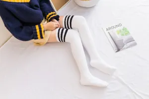 Απαλές λευκές κάλτσες πάνω από το γόνατο από fleece με μαύρες ρίγες για ζεστασιά στο σπίτι.