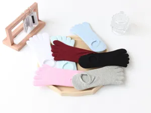 Close-up view of comfortable women five toe socks in various colors on wooden tray detail