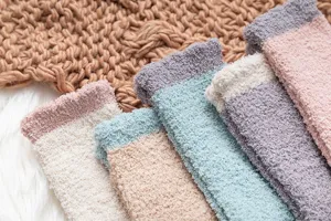 Cozy fleece socks detail shot, soft coral velvet texture, warm winter sleep socks close up.