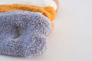 Close-up detail of cozy coral fleece sleeping socks with cute embroidery, soft and warm texture.