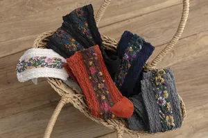 Gros plan détaillé de chaussettes en tricot floral vintage présentées dans un panier.