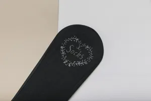Close-up detail of black ice silk boat sock featuring elegant heart floral embroidery.