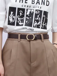 Detailed view of a vintage thin brown leather belt with gold metal buckle worn on trousers.