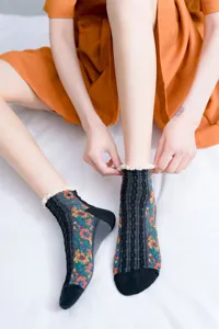 Close-up shot of women's floral vintage socks with delicate lace trim detail on white background.
