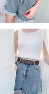 Close-up detail of the elastic invisible belt worn with denim shorts, showing buckle.