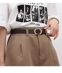 Detail shot of a slim leather belt with metallic buckle, paired with casual trousers.