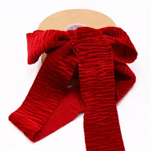 Close up view of red velvet ribbon roll, showing soft texture and fine design for decor.