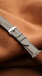 Graues Echtleder-Uhrenarmband Detail mit exquisiter silberner Metallschließe und sauberer weißer Naht.