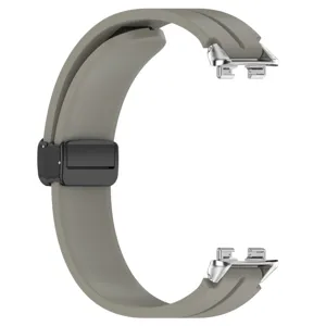 Dettaglio cinturino orologio in silicone, cinturino grigio con connettore e chiusura magnetica.
