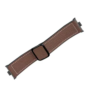 Close-up of brown leather watch strap texture, white stitching and black magnetic buckle.