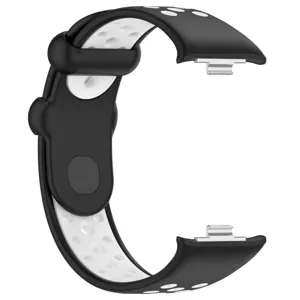 Gros plan d'un bracelet de montre en silicone noir et blanc avec trous et connecteurs.