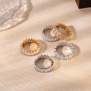 Detailed close-up of sparkling cubic zirconia eternity rings in gold and silver tones for women.