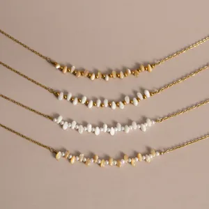 Titanium steel 18K gold bead U-shaped necklace with natural trochus and delicate rice pearls.