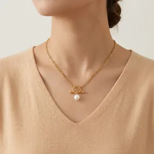 Primer plano detallado de un delicado collar de cadena bañado en oro con perla.