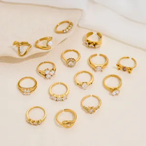 Set of 14 minimalist gold-plated open rings with cubic zirconia and faux pearls for women fashion.