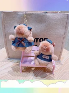 Cute capybara plush toy keychain detail, denim clothes and mini bench display scene closeup.