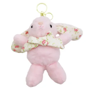 Grazioso portachiavi con coniglietto in peluche rosa con orecchie e fiocco floreale.