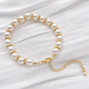 Primer plano de elegante pulsera de perlas con cuentas espaciadoras metálicas doradas.