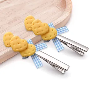 Detail shot of cute heart biscuit hair clips with blue plaid bows and metal duckbill clips.