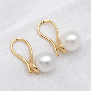 Close-up detail of copper 18K gold plated ear hooks with white pearl bead trays, DIY jewelry.