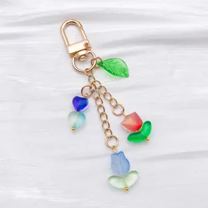Close-up detail of the colorful gradient glass tulip and heart pendant charm on gold keyring chain.